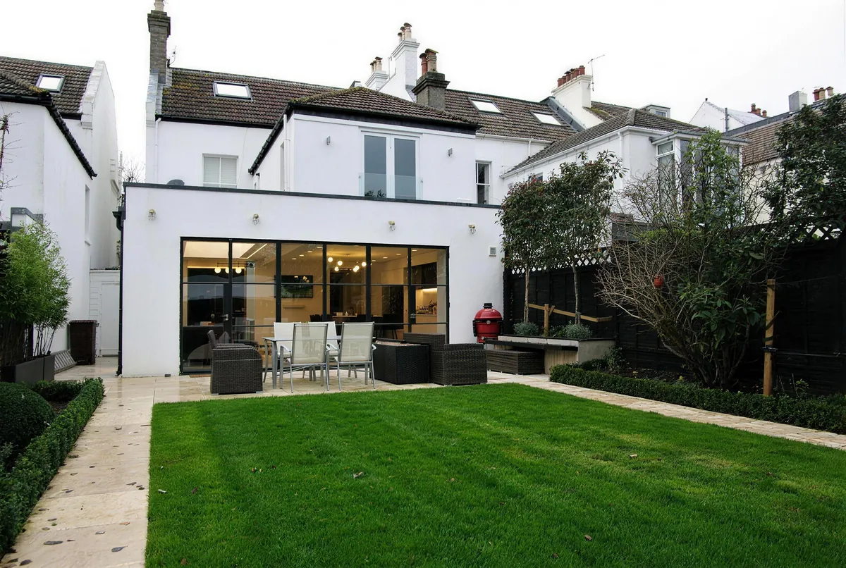 Finished rear extension with full-width glazed doors opening onto the lawn at Hove Park Villas