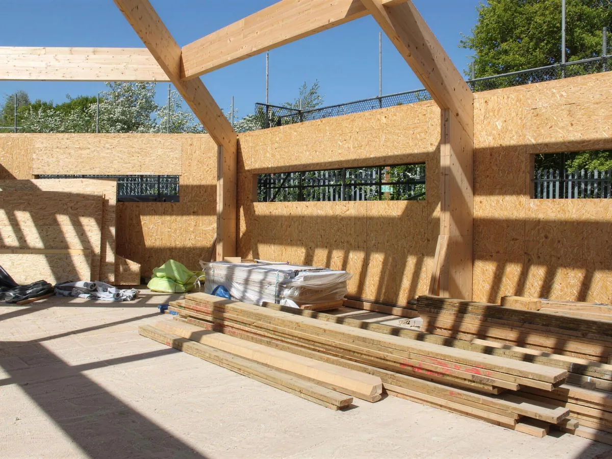 Walls of the Link Barn closed in around the glulam frame, with high slot windows