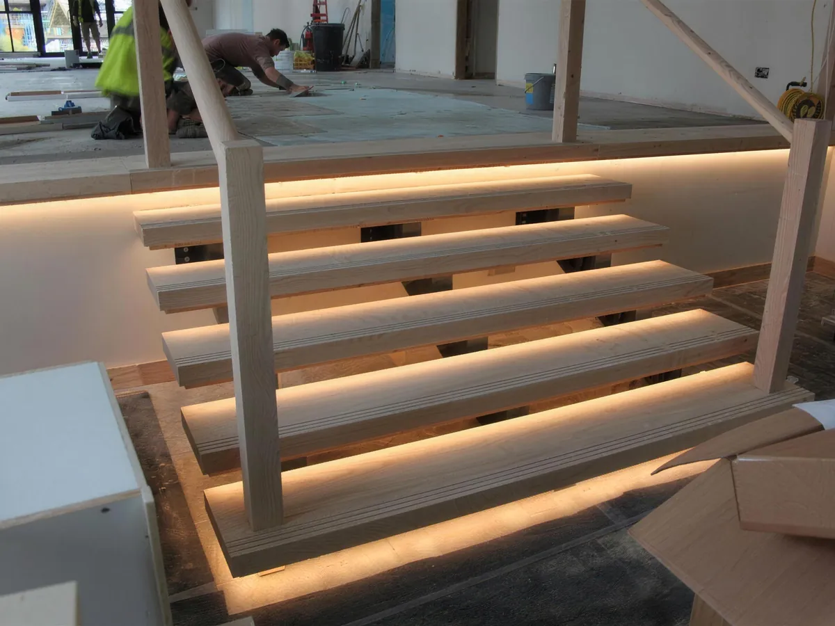 Bespoke timber steps with built-in lighting being fitted in the Link Barn