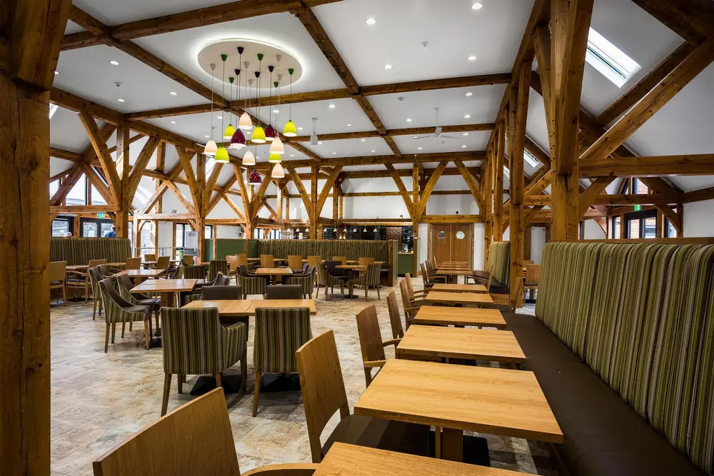 Inside the oak-framed coffee shop at South Downs Garden Centre, with long timber tables and booth seating
