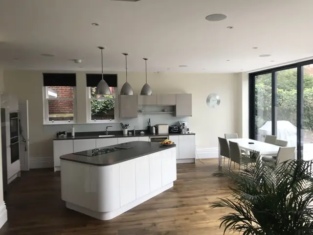 Kitchen with a white curved island and glazed doors